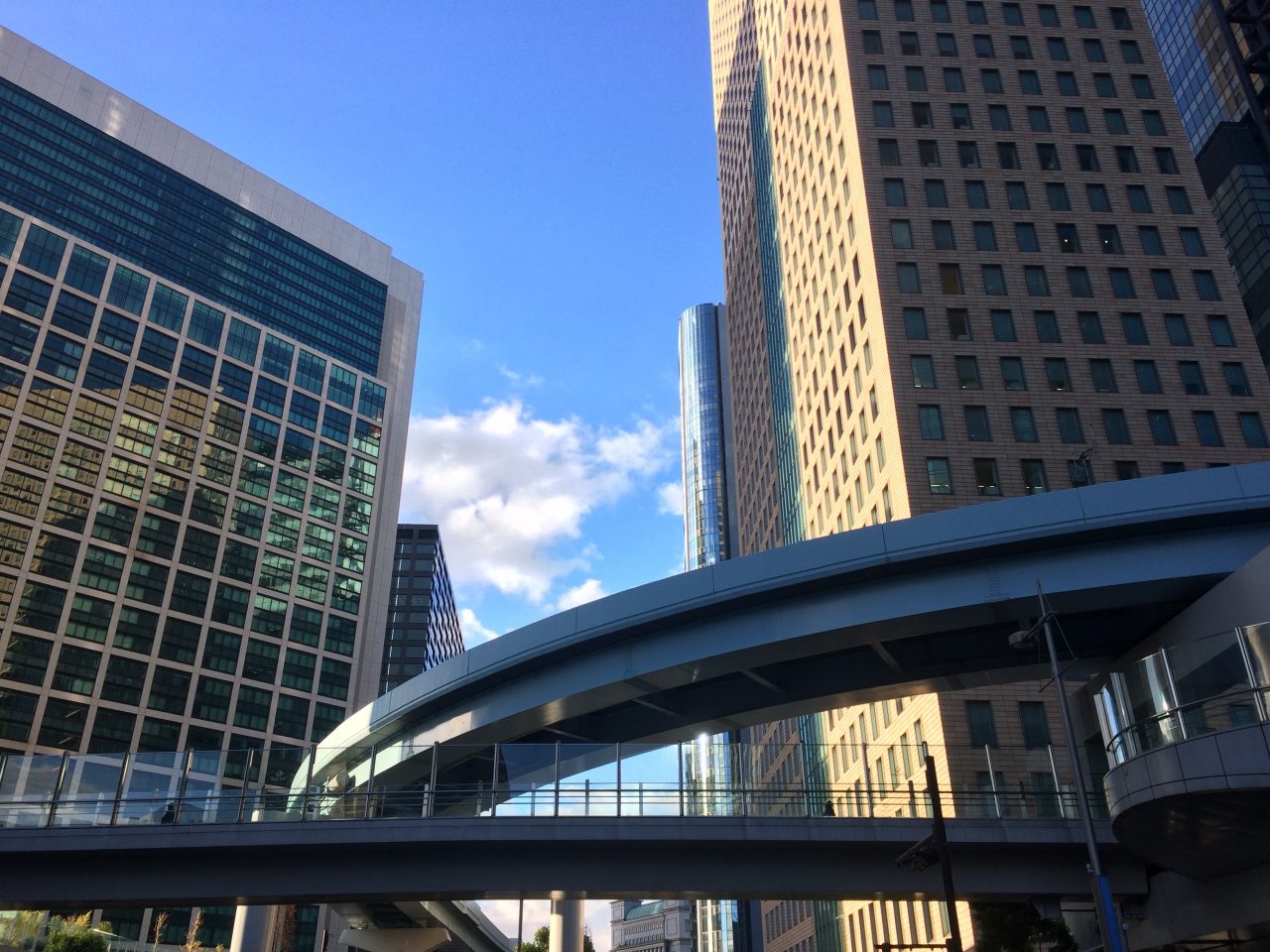 汐留の高層ビルとゆりかもめの高架と歩道橋の写真