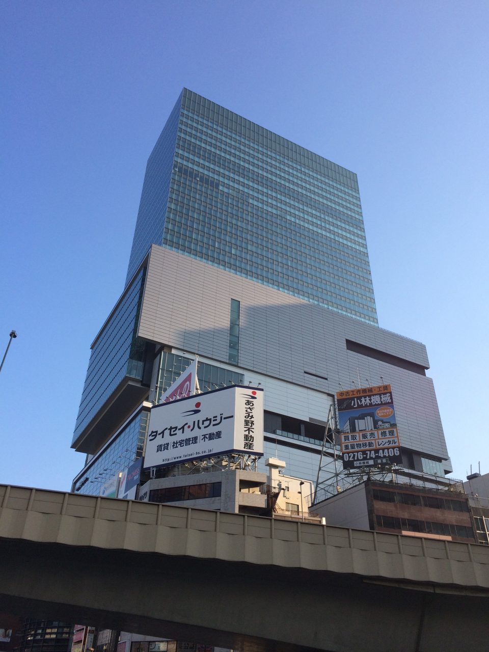 渋谷ヒカリエと雑居ビルの看板・首都高の高架の写真