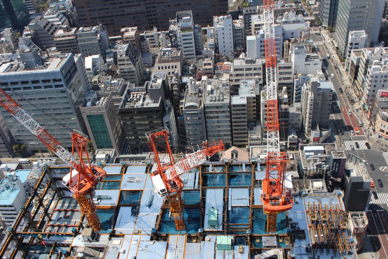 展望台から見下ろした建設中の高層ビルとタワークレーンの写真